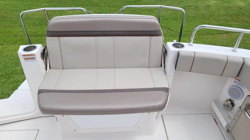 Slide: The Image of 2021 Cutwater C-28 boat seating area with cushioned bench and cup holders. - 17