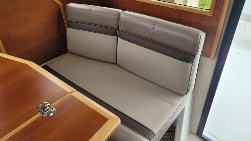 Slide: The Image of 2021 Cutwater C-28 interior with gray cushioned seating and wooden table. - 20