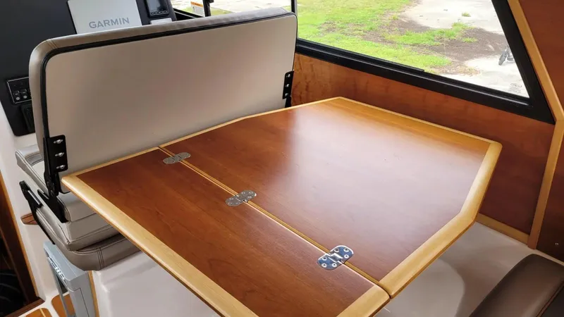 Slide: The Image of 2021 Cutwater C-28 interior with wooden foldable table and Garmin navigation system. - 25