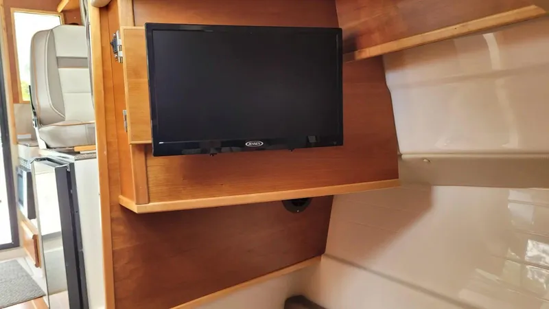 Slide: The Image of 2021 Cutwater C-28 interior with mounted TV on wooden panel. - 27
