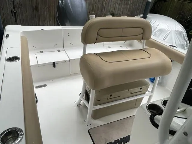 Slide: The Image of 2014 Sportsman Heritage 231 Center Console boat interior with beige seating and storage. - 14