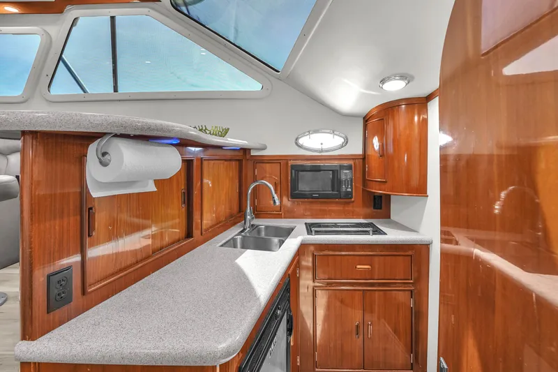 Slide: The Image of Luxurious kitchen interior of 2001 Mediterranean 38 Convertible yacht with wood cabinetry and modern appliances. - 20