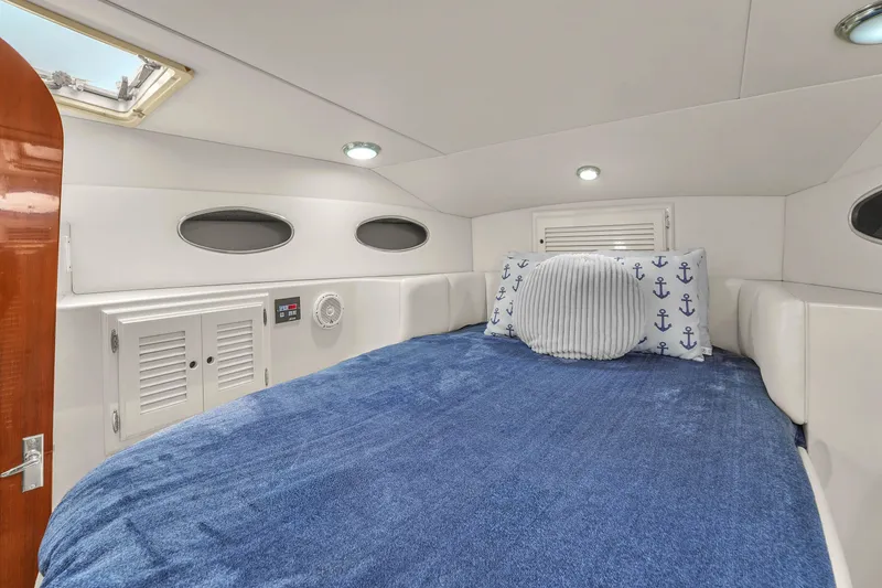 Slide: The Image of Cozy cabin interior of 2001 Mediterranean 38 Convertible yacht with blue bedding and nautical decor. - 26