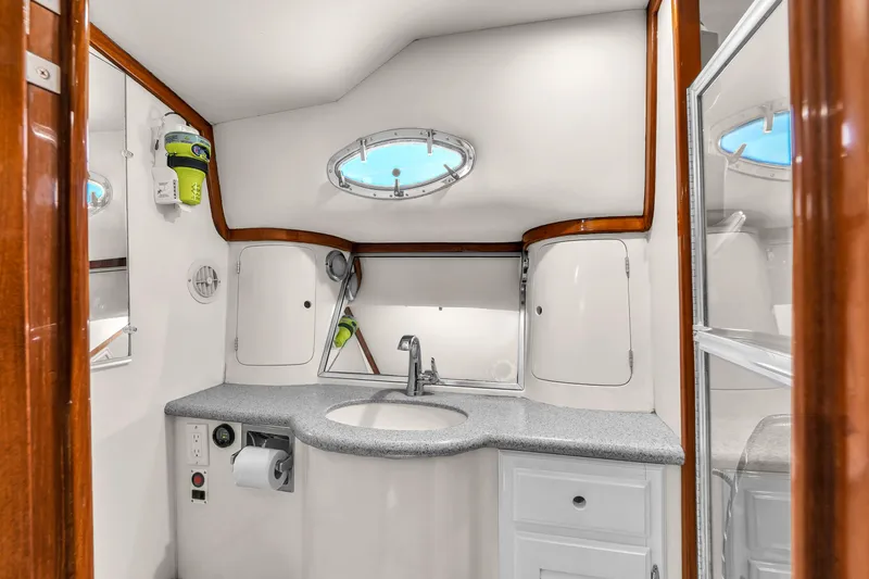Slide: The Image of 2001 Mediterranean 38 Convertible yacht bathroom with sink, storage, and porthole window. - 27