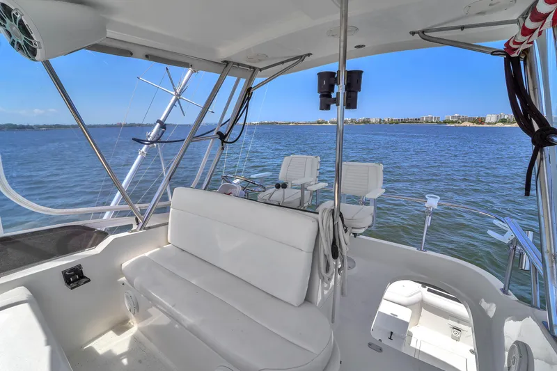 Slide: The Image of 2001 Mediterranean 38 Convertible yacht interior with white seating, overlooking calm blue waters. - 33