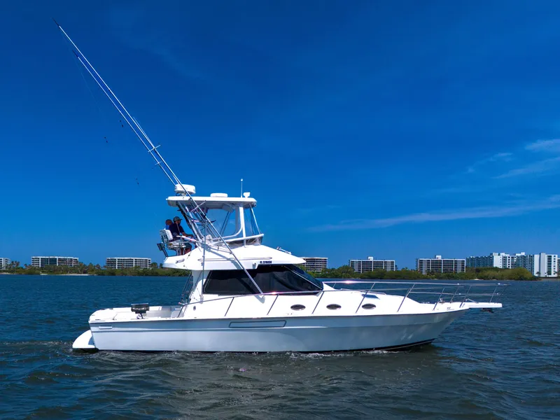 Slide: The Image of 2001 Mediterranean 38 Convertible yacht cruising on a sunny day with cityscape in the background. - 40