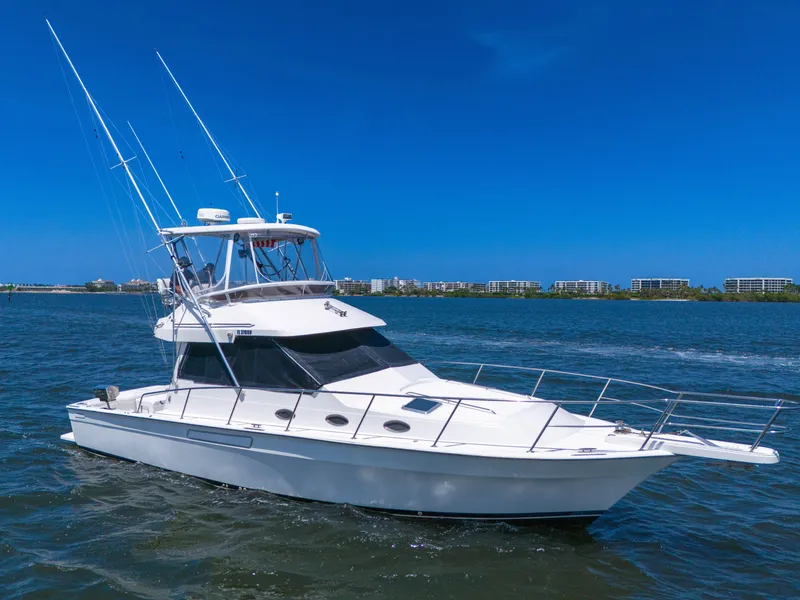 Slide: The Image of 2001 Mediterranean 38 Convertible yacht cruising on open water under clear blue sky. - 41