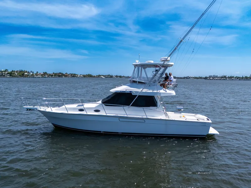 Slide: The Image of 2001 Mediterranean 38 Convertible yacht on calm waters under a clear blue sky. - 46