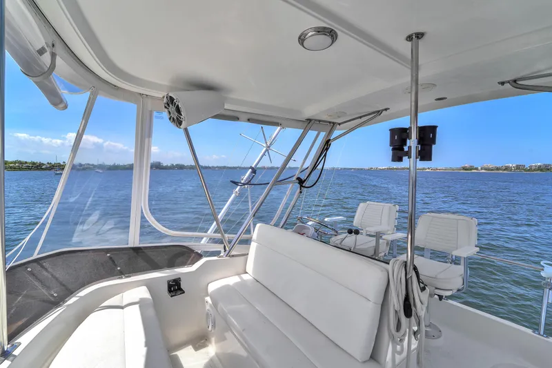 Slide: The Image of 2001 Mediterranean 38 Convertible yacht interior with seating, overlooking serene water and distant shoreline. - 5