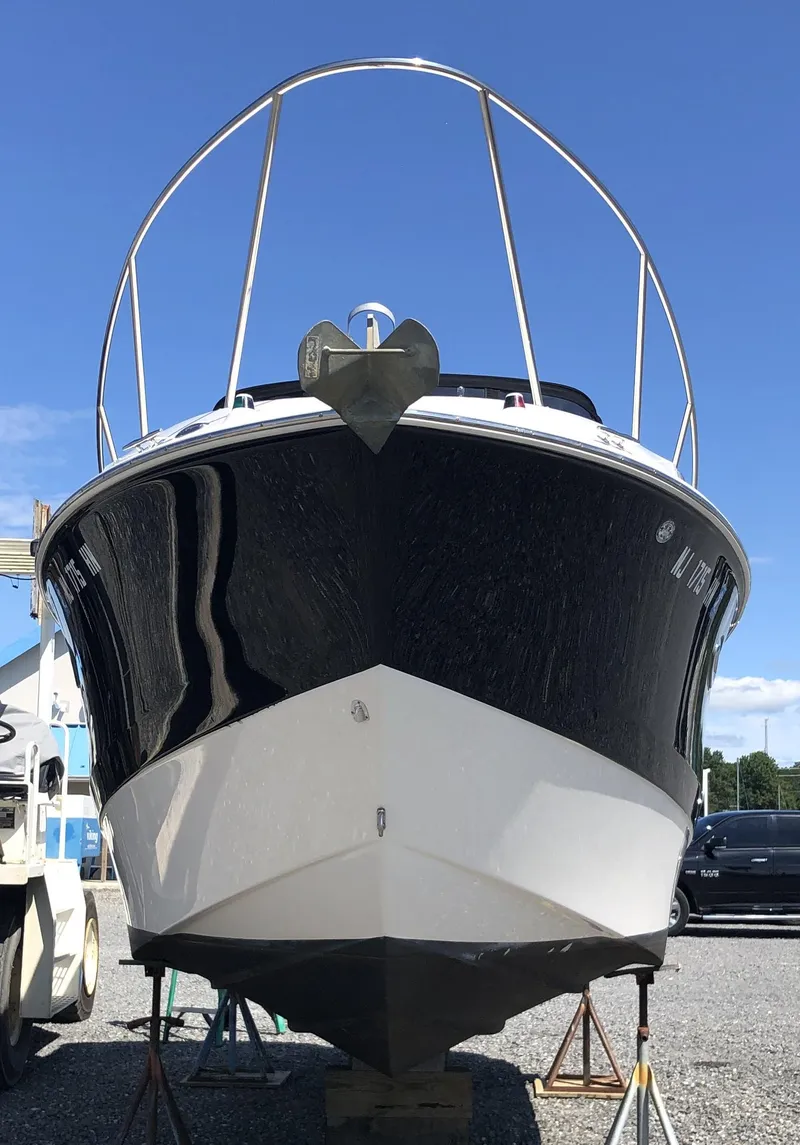 Slide: The Image of 2012 Bayliner 255 Cruiser boat on display under clear blue sky. - 13