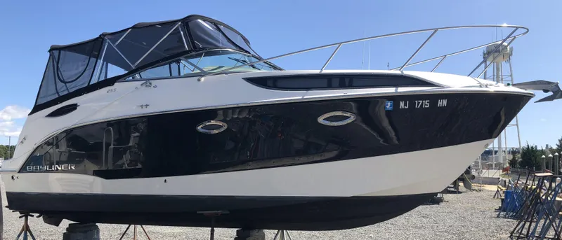 Slide: The Image of 2012 Bayliner 255 Cruiser boat on stands, black and white exterior, outdoor setting. - 14