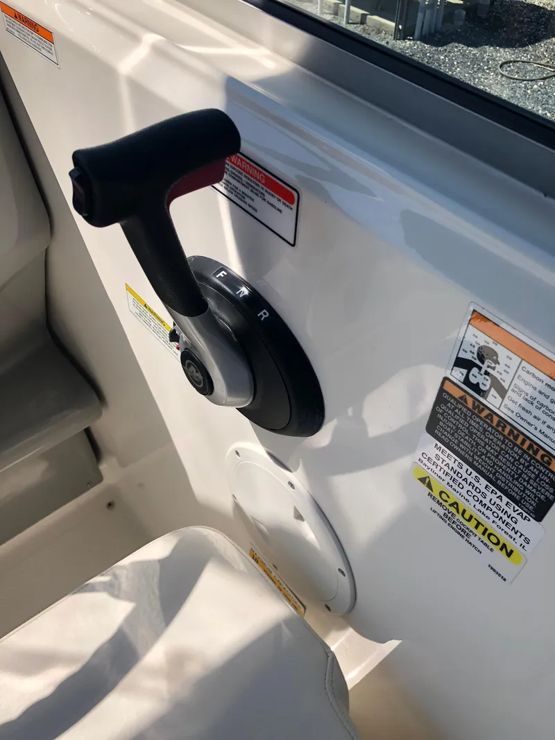 Slide: The Image of 2012 Bayliner 255 Cruiser throttle control with caution labels on white panel. - 16