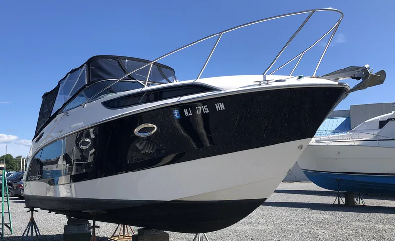 Slide: The Image of 2012 Bayliner 255 Cruiser boat on display, featuring sleek design and black hull. - 21