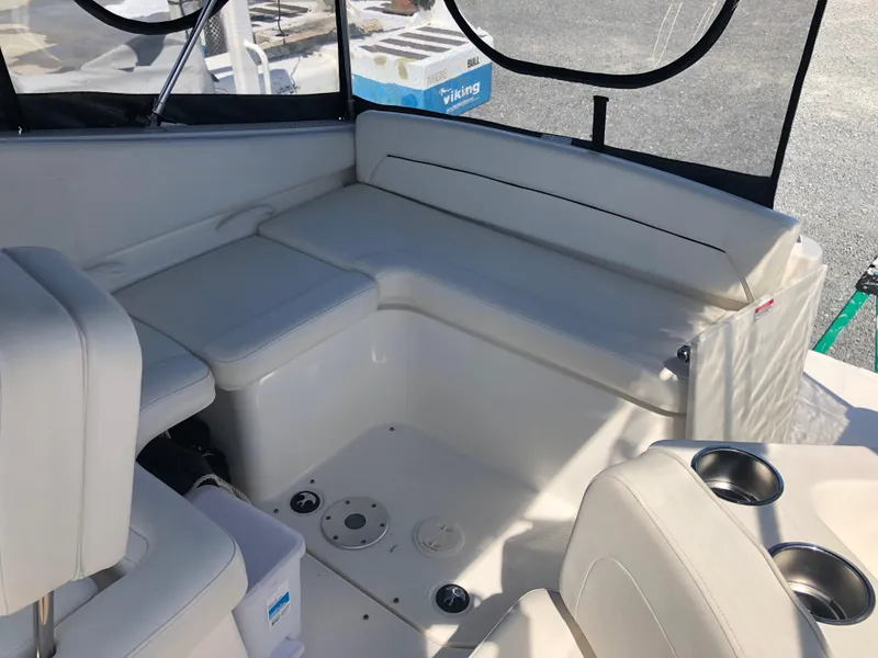Slide: The Image of 2012 Bayliner 255 Cruiser interior with white seating and cup holders. - 22