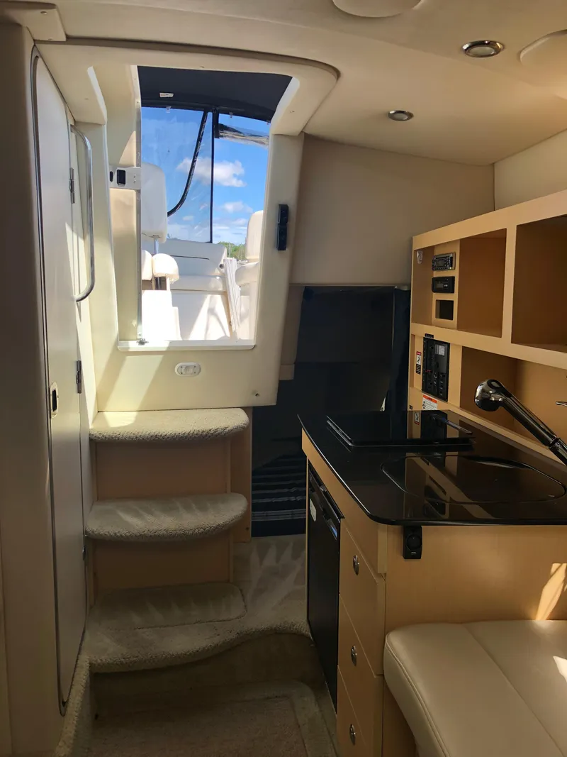Slide: The Image of Interior of 2012 Bayliner 255 Cruiser with kitchenette and steps to deck. - 26