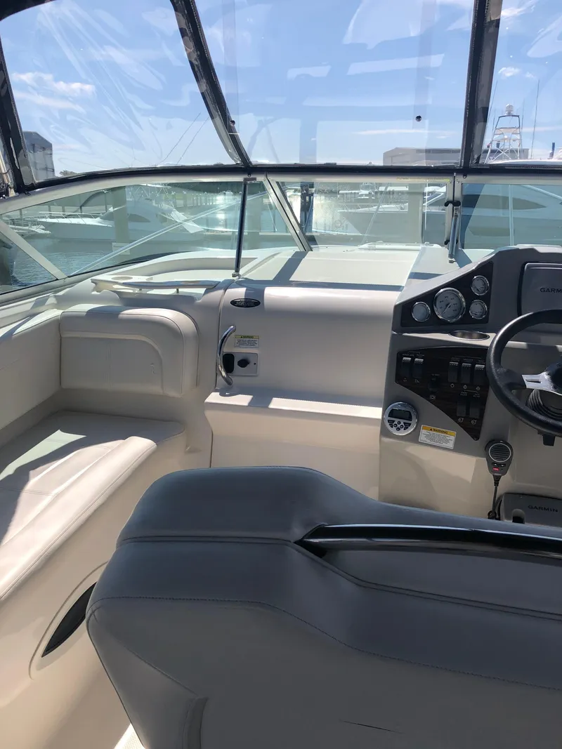 Slide: The Image of 2012 Bayliner 255 Cruiser cockpit with steering wheel and seating under clear skies. - 40