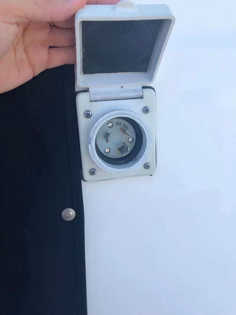Slide: The Image of 2012 Bayliner 255 Cruiser shore power inlet with protective cover open. - 43