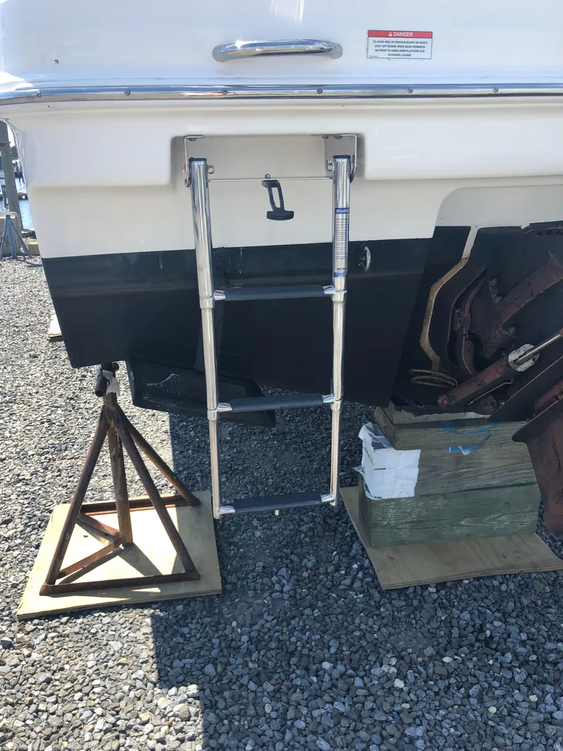 Slide: The Image of 2012 Bayliner 255 Cruiser with ladder, displayed on gravel with support stands. - 44