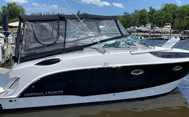 Slide: The Image of 2012 Bayliner 255 Cruiser docked at a marina, featuring a sleek black and white design. - 45