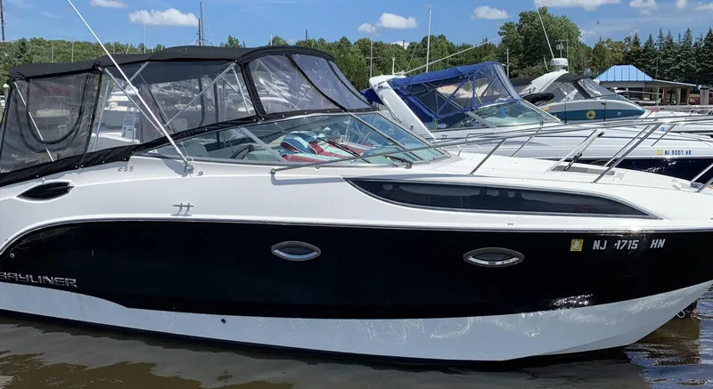 Slide: The Image of 2012 Bayliner 255 Cruiser docked at marina, featuring sleek black and white design. - 47