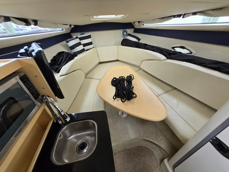 Slide: The Image of Interior of 2012 Bayliner 255 Cruiser with seating, table, sink, and modern amenities. - 49