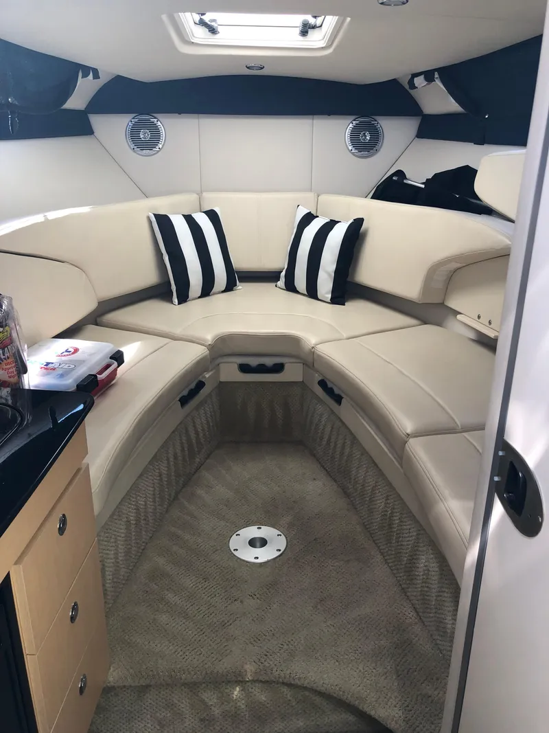 Slide: The Image of Interior of 2012 Bayliner 255 Cruiser with beige seating and striped pillows. - 6