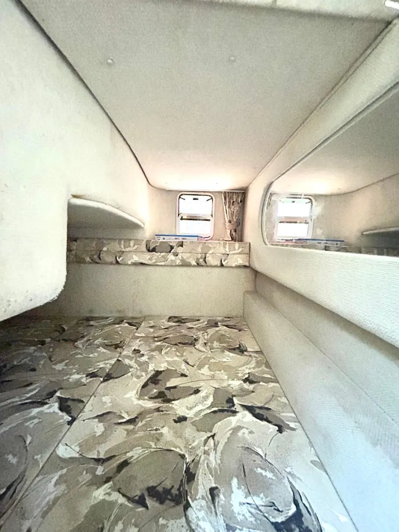 Slide: The Image of Interior cabin of 1999 Sea Ray 270 Sundancer with patterned upholstery and windows. - 11
