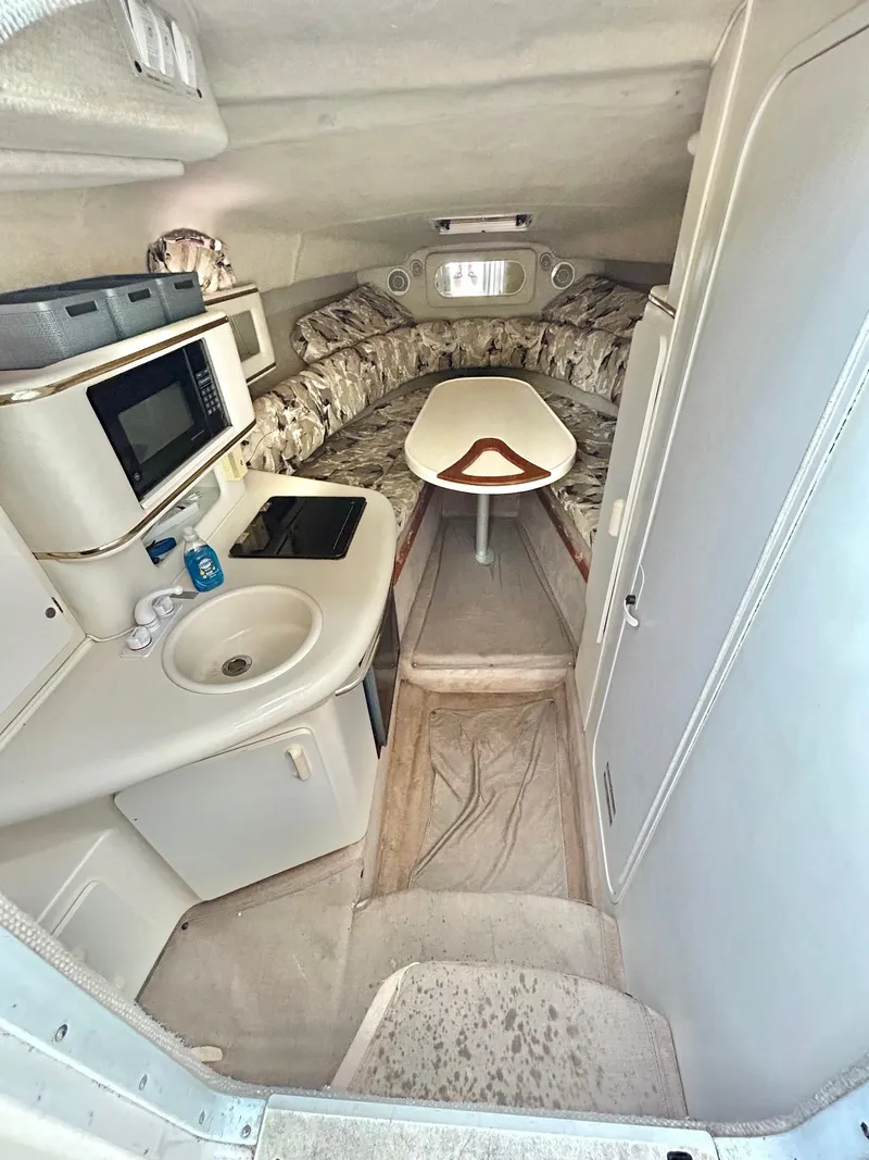 Slide: The Image of 1999 Sea Ray 270 Sundancer cabin interior with kitchenette and seating area. - 15