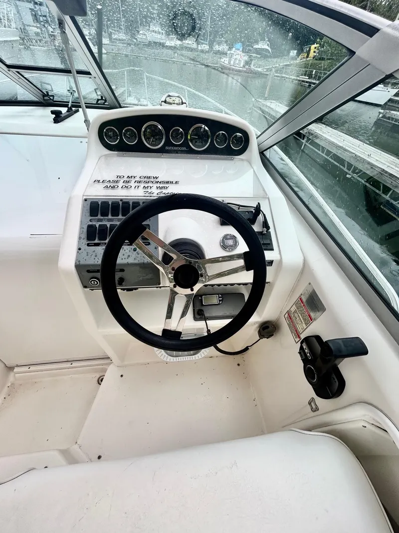 Slide: The Image of 1999 Sea Ray 270 Sundancer helm with steering wheel and control panel. - 7