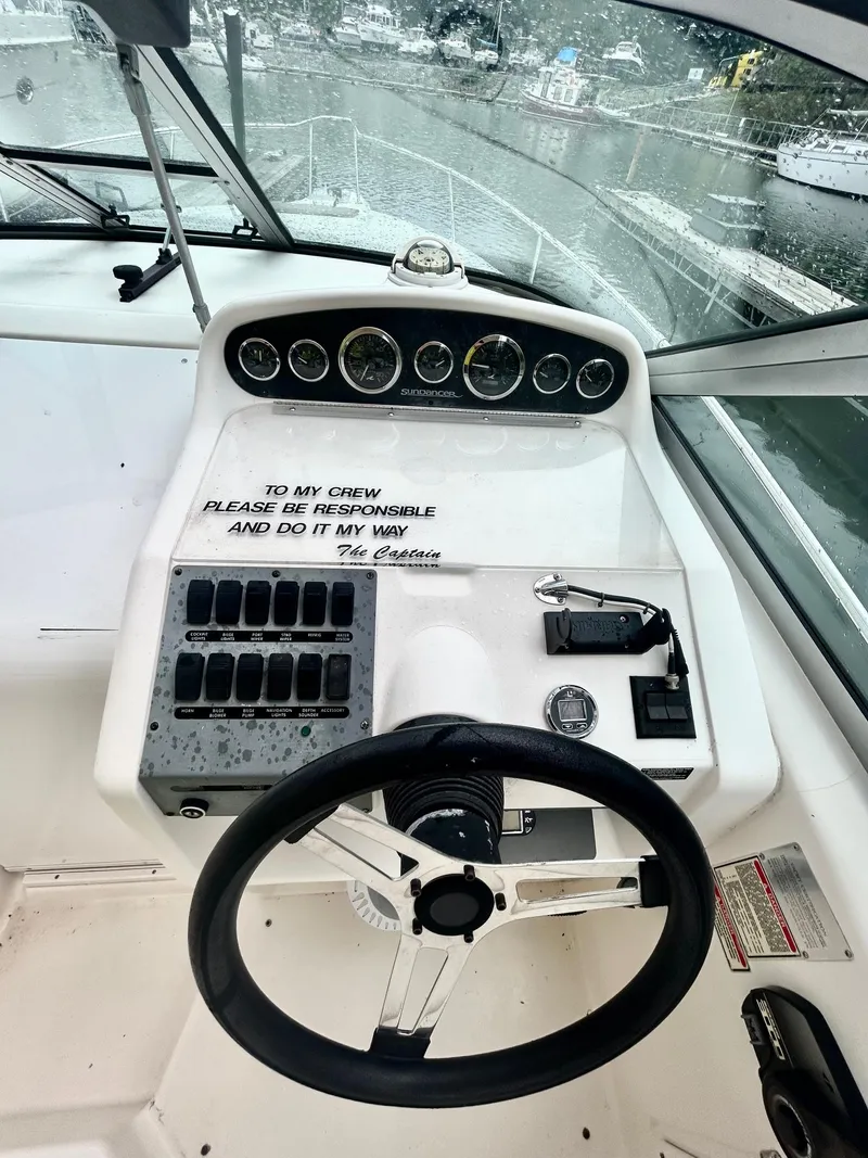 Slide: The Image of 1999 Sea Ray 270 Sundancer helm with steering wheel and control panel. - 8