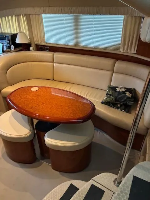 Slide: The Image of 2004 Sea Ray 390 Motor Yacht interior with beige seating and wooden table. - 23