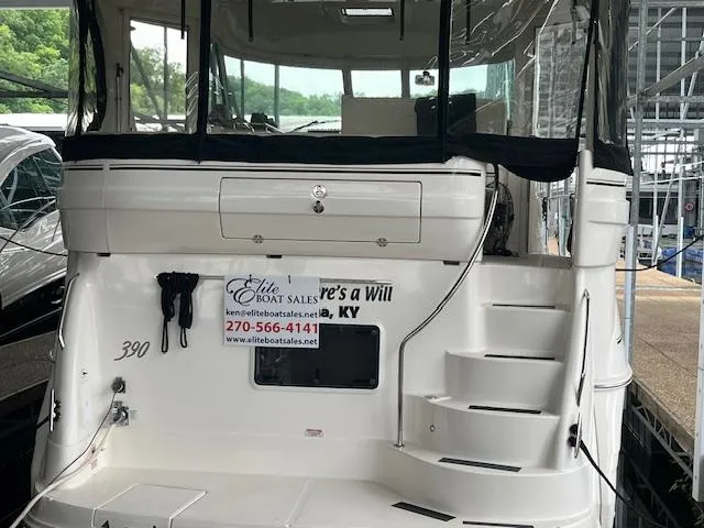 Slide: The Image of 2004 Sea Ray 390 Motor Yacht docked, featuring rear view with stairs and sales contact details. - 3