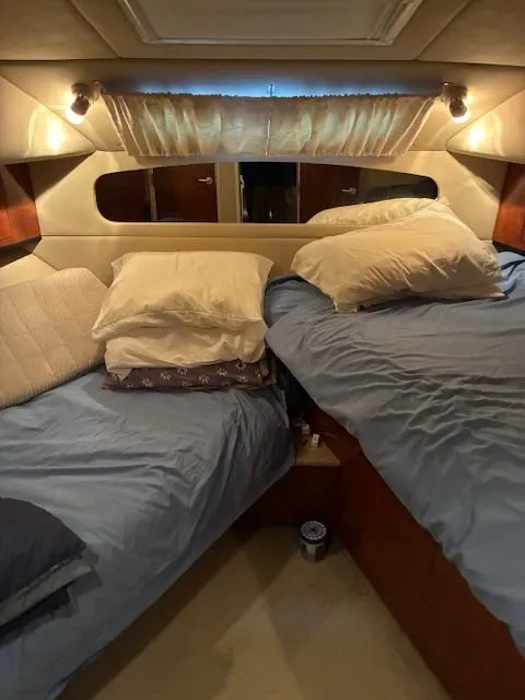 Slide: The Image of 2004 Sea Ray 390 Motor Yacht cabin with twin beds and cozy lighting. - 31