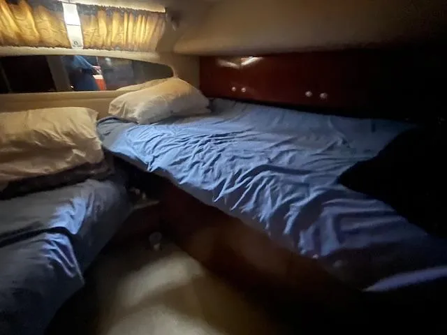 Slide: The Image of Cozy cabin interior of 2004 Sea Ray 390 Motor Yacht with twin beds and blue bedding. - 33