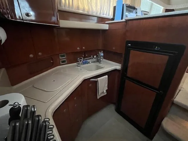 Slide: The Image of 2004 Sea Ray 390 Motor Yacht kitchen with wood cabinets and compact appliances. - 36