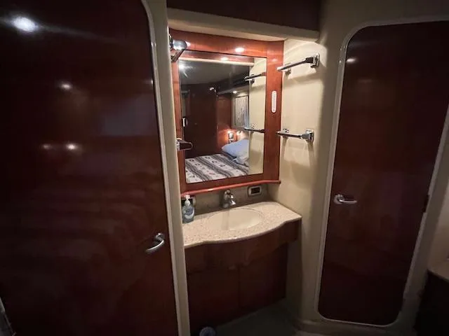 Slide: The Image of 2004 Sea Ray 390 Motor Yacht bathroom with mirror, sink, and wooden cabinetry. - 37