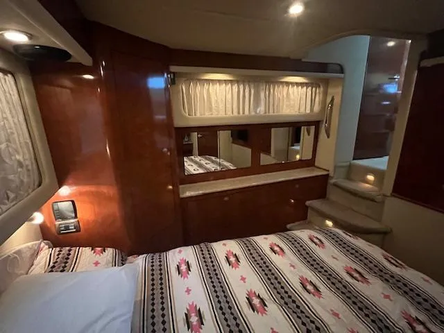 Slide: The Image of Luxurious 2004 Sea Ray 390 Motor Yacht bedroom with elegant wood paneling and cozy bedding. - 40