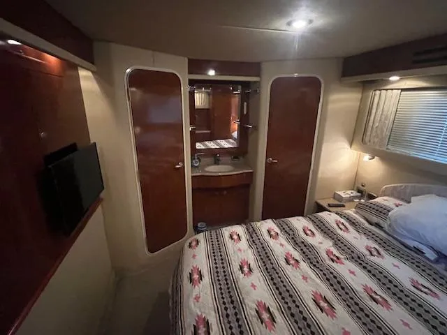 Slide: The Image of Luxurious 2004 Sea Ray 390 Motor Yacht bedroom with patterned bedding and modern amenities. - 42