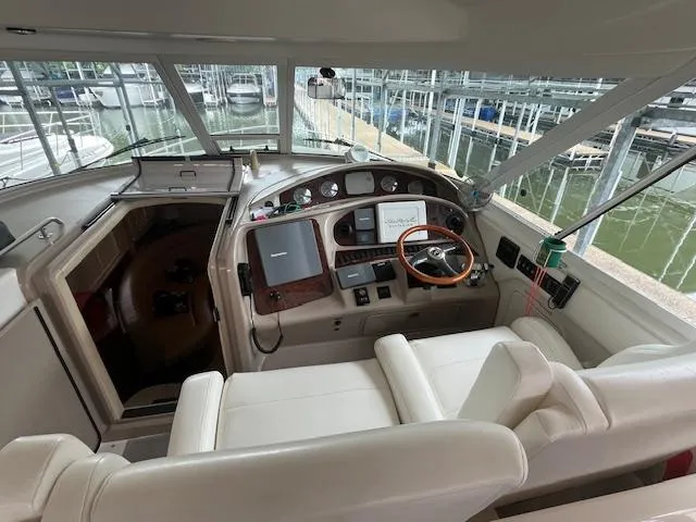 Slide: The Image of 2004 Sea Ray 390 Motor Yacht helm with leather seating and modern navigation equipment. - 9