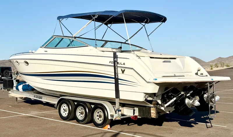 Slide: The Image of 2000 Formula 330 Sun Sport boat on trailer, parked outdoors under clear sky. - 4
