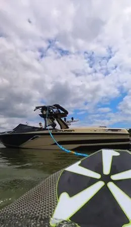 Slide: The Image of 2021 Centurion Ri265 boat on water, cloudy sky, wakeboard in foreground. - 10