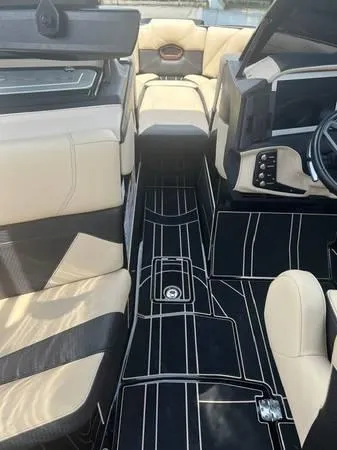 Slide: The Image of 2021 Centurion Ri265 boat interior with beige and black seating, modern dashboard, and sleek flooring. - 13