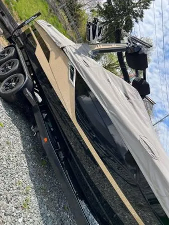 Slide: The Image of 2021 Centurion Ri265 boat on trailer, covered, parked on gravel. - 3