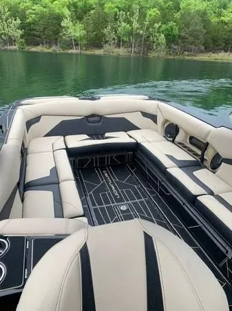 Slide: The Image of 2021 Centurion Ri265 boat interior with beige and black seating on a lake. - 4