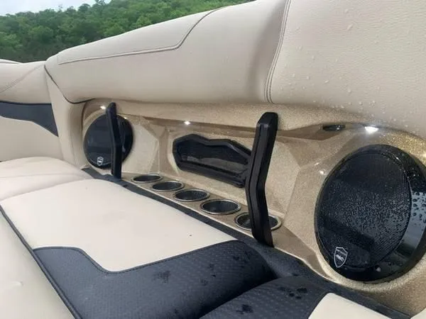 Slide: The Image of 2021 Centurion Ri265 boat interior with beige seating, cup holders, and speakers. - 5