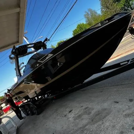 Slide: The Image of 2021 Centurion Ri265 boat on trailer, black exterior, parked outdoors. - 7