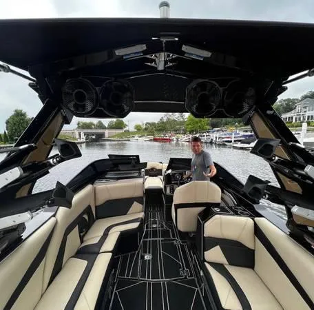 Slide: The Image of 2021 Centurion Ri265 boat interior with luxury seating and advanced sound system on a scenic lake. - 9