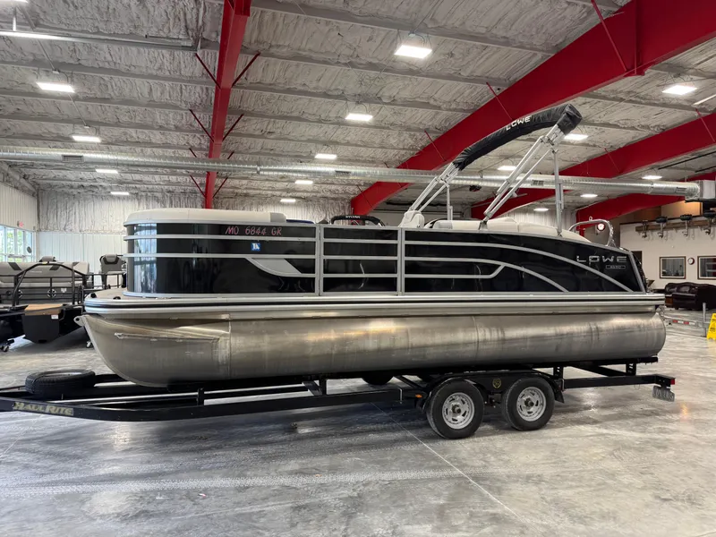 Slide: The Image of 2022 Lowe 210 SS pontoon boat on trailer in indoor showroom. - 1