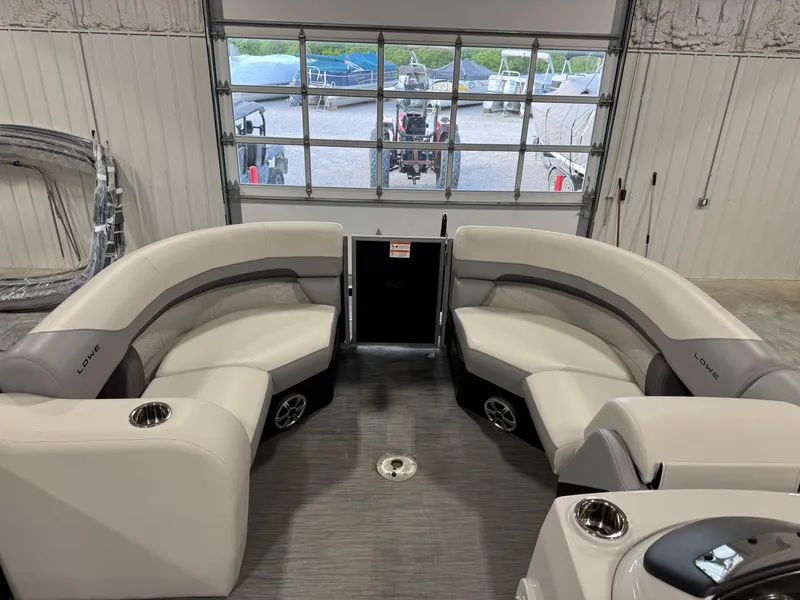 Slide: The Image of 2022 Lowe 210 SS boat interior with curved seating and cup holders in a showroom. - 11