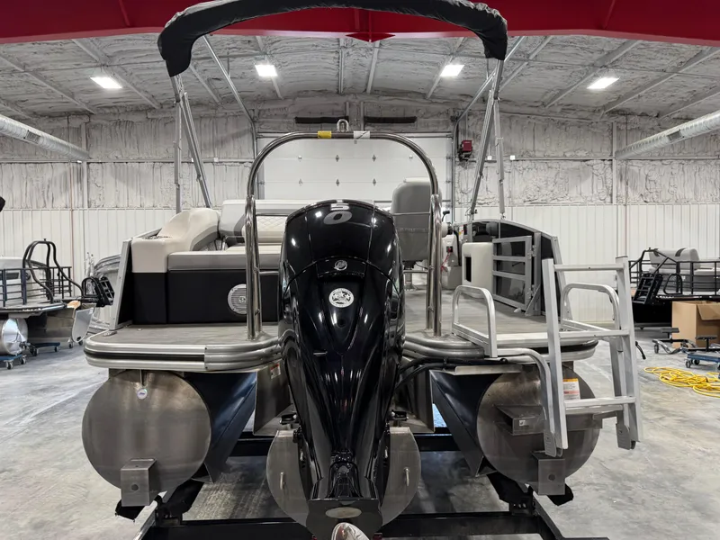 Slide: The Image of 2022 Lowe 210 SS pontoon boat in a warehouse, rear view with motor and ladder. - 6